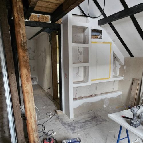 und der Stromkasten verschwindet in der Wand, umbaut von integrierten Regalen.