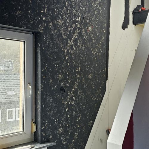 Noch zwei Bahnen von der schwarzgoldenen Tapete, dann kann die Treppe eingebaut werden!